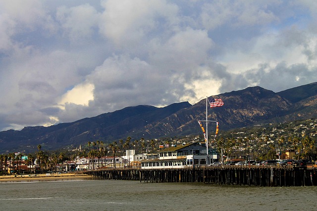 Santa Barbara travel guide image of Stearns Wharf with ocean views, mountains, and dramatic clouds