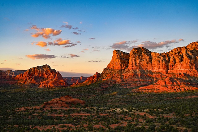 Sedona travel guide image of red rock formations glowing at sunset under a blue Arizona sky